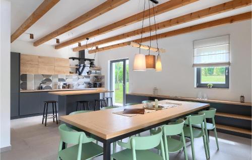 une cuisine avec une table en bois et des chaises vertes dans l'établissement Villa Fritula, à Vižinada
