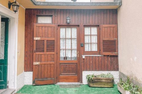 a wooden garage door with two windows and a crate at Dolce Barzio - piccolo bilocale in Barzio