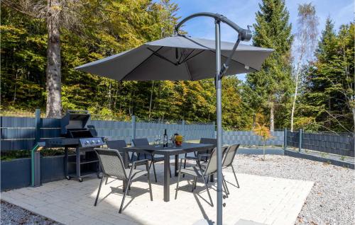 a table and chairs under an umbrella with a grill at Nice Home In Stari Laz With Kitchen in Stari Laz