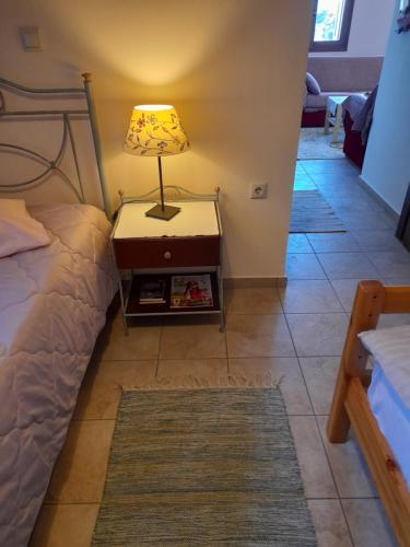 a lamp on a night stand next to a bed at Anta's bnb in Ambelókipoi