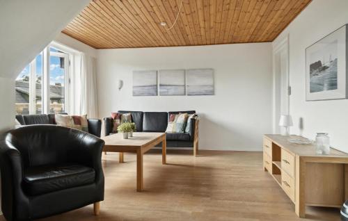 a living room with a couch and a table at Nice Home In Ørum Djurs With Sauna in Nimtofte