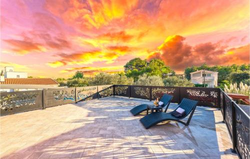 a patio with two chairs and a table with a sunset at Beach Front Home In Vir in Vir