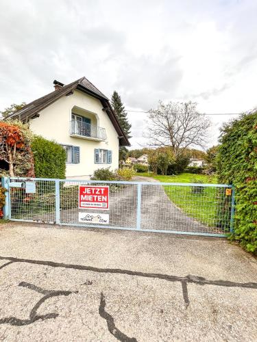 a gate with a sign in front of a house at Luxuriöses Bauernhaus mit Garten und Parkplatz in Straß in Steiermark