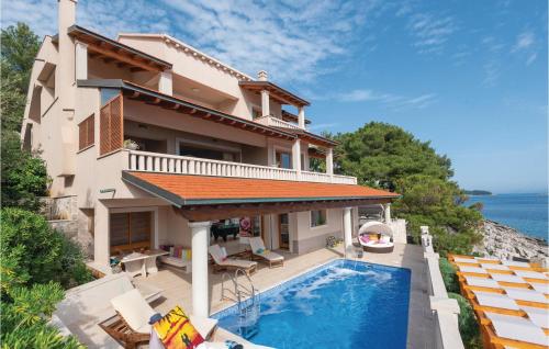 a villa with a swimming pool in front of a house at Nice Home In Prizba With Sauna in Prizba