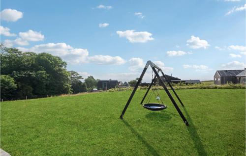 a swing in the middle of a grass field at Four-Bedroom Holiday Home In Haderslev in Haderslev