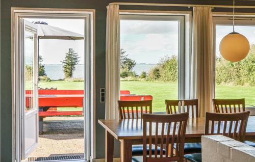 a dining room with a table and chairs and sliding glass doors at Stunning Home In Spøttrup With Sauna in Vadum