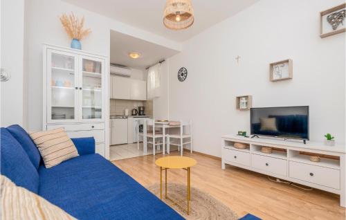a living room with a blue couch and a kitchen at 1 Bedroom Awesome Apartment In Podaca in Podaca
