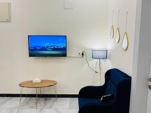 a living room with a blue couch and a tv on a wall at Diamond apartments, شقق الماس الحديثة- حي القادسية اليرموك in Baghdad