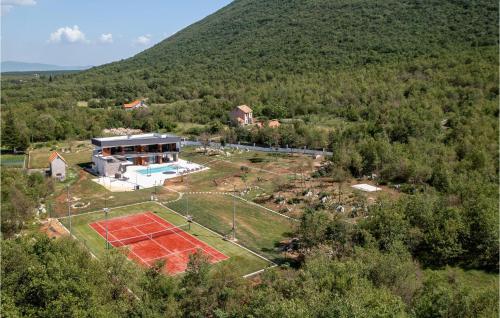vista aerea di una casa con campo da tennis di Amazing Home In Radosic a Radošić