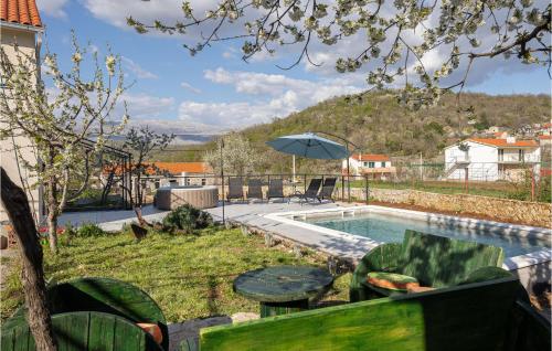 a swimming pool with a table and an umbrella at Lovely Home In Ramljane in Ramljane