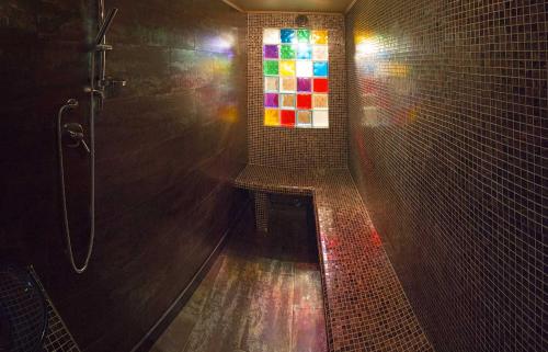 a bathroom with a shower with a stained glass window at Country Hotel Poggiomanente in Umbertide