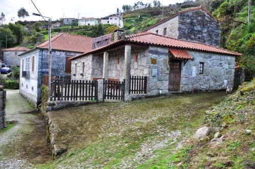 a stone house with a fence in front of it at Casa de Fora in Fafe