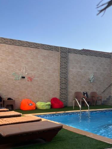 a swimming pool with colorful pillows next to a brick wall at King House in Sharm El Sheikh