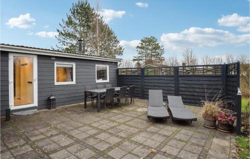 une terrasse avec une table et des chaises ainsi qu'une maison dans l'établissement Cozy Home In Haderslev With Wifi, à Haderslev