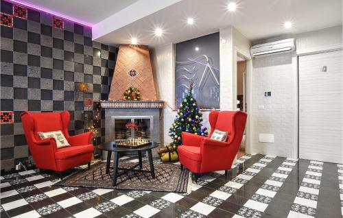 a lobby with a christmas tree and two chairs and a fireplace at Nice Home In Sant'alfio With Sauna in SantʼAlfio