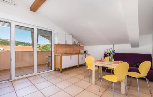 a kitchen and dining room with yellow chairs and a table at 1 Bedroom Cozy Apartment In Palit in Palit