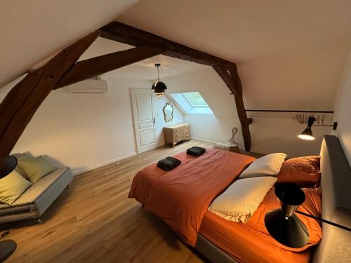 a bedroom with a large bed in a attic at Évasion champêtre in Ambillou