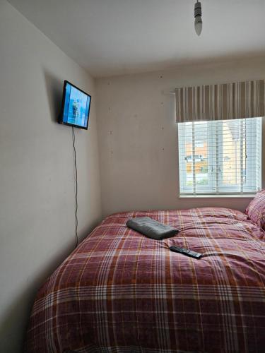 ニューカッスル・アポン・タインにあるBridgepay Double Room Newcastleの壁にテレビが付いたベッドのある寝室