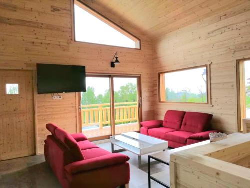 Il comprend un salon doté d'un mobilier rouge et d'une télévision à écran plat. dans l'établissement L'El Cadi, à Font-Romeu