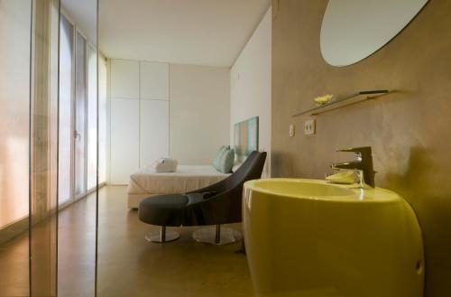 a bathroom with a yellow sink and a bed at Hotel Viento10 in Córdoba