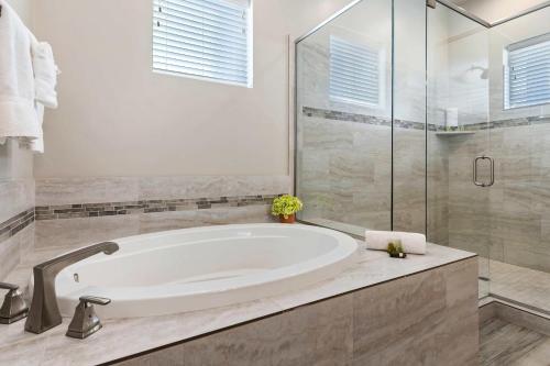 a white bathroom with a tub and a glass shower at 30-31| 2 Homes in St George with Private Pools and Hot Tubs in Santa Clara