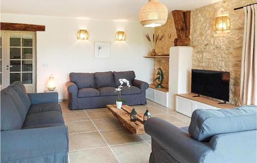 un salon avec des canapés bleus et une télévision dans l'établissement Awesome Home In Lussas Et Nontronneau, à Lussas-et-Nontronneau