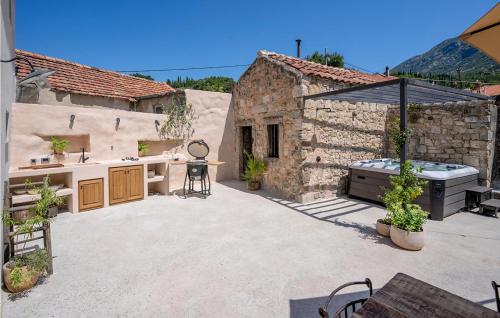 an outdoor patio with a kitchen and an outdoor grill at Lovely Home In Gruda With Sauna in Gruda