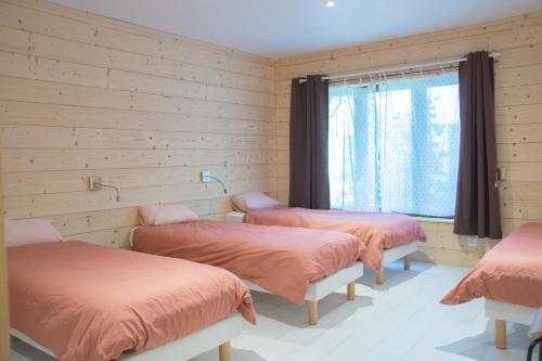 une chambre avec trois lits et une fenêtre dans l'établissement Grand appartement vue Montagne plein sud grand garage sur demande, à Font-Romeu