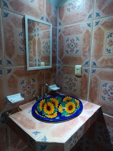a bathroom with a sink with a flower plate on it at HOTEL ATLANTIDA in Playa del Carmen