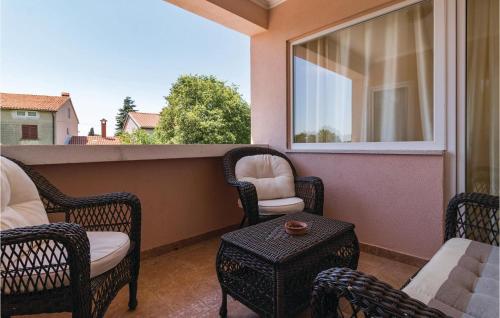 a balcony with chairs and a table and a window at Awesome Home In Valbandon in Štinjan
