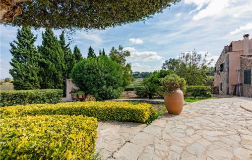 wazon siedzący na kamiennym chodniku w ogrodzie w obiekcie Awesome Home In Sineu w mieście Sineu