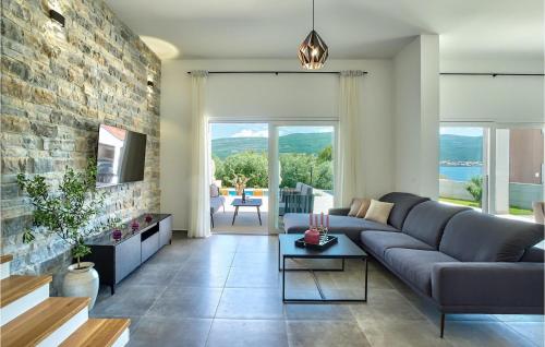 a living room with a couch and a brick wall at Villa Ena Mar in Zadar