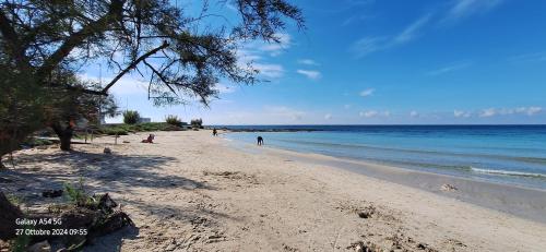 a sandy beach with people on the water at "Casa Simone" in Leverano