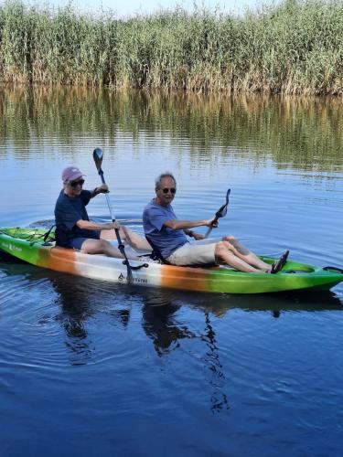 two men are sitting in a kayak on the water at Hotel Stedswal in Sloten
