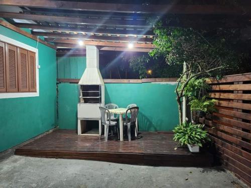 a patio with a table and chairs and a stove at Casa de praia in Passo de Torres