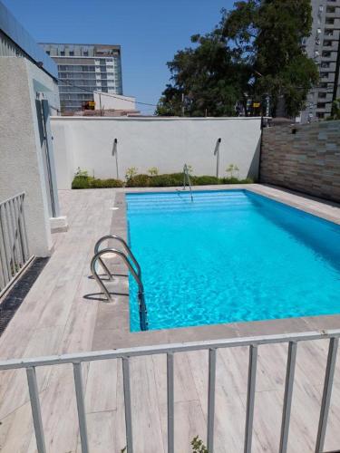 a large blue swimming pool with a fence around it at Departamento la Cisterna in Santiago