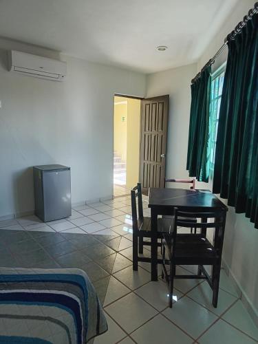 a room with a table and chairs and a television at HOTEL ATLANTIDA in Playa del Carmen