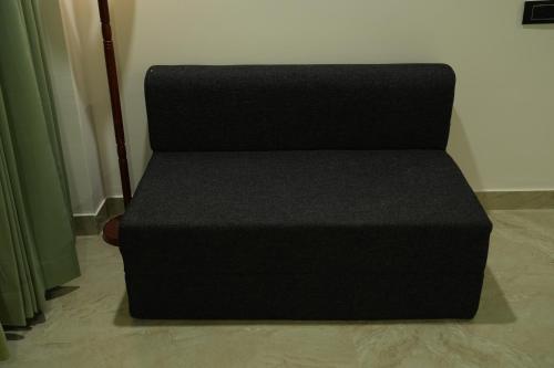 a black couch sitting in the corner of a room at SKD RESORT AND CLUB in Barvāla