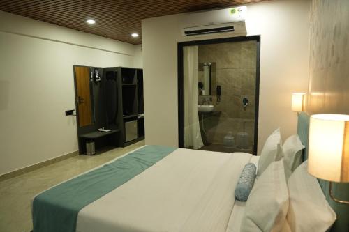 a bedroom with a bed and a bathroom with a shower at SKD RESORT AND CLUB in Barvāla
