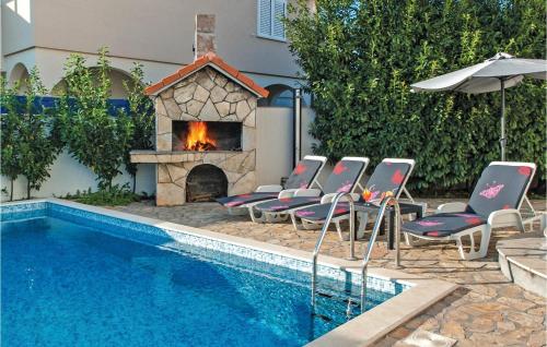 a swimming pool with chairs and a fireplace next to a house at Seahorse Apartments in Ražanj