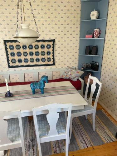 a dining room table with two chairs and a white table and chairsktop at Stuga i Solvarbo, Dalarna in Gustafs