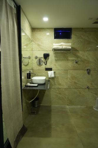 a bathroom with a sink and a shower at SKD RESORT AND CLUB in Barvāla