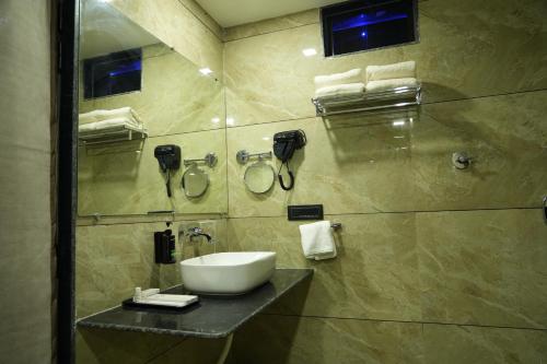 a bathroom with a sink and a shower at SKD RESORT AND CLUB in Barvāla