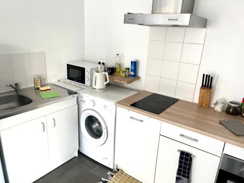 - une cuisine blanche avec lave-linge et four micro-ondes dans l'établissement Appartement Muse proche Gare, à Metz