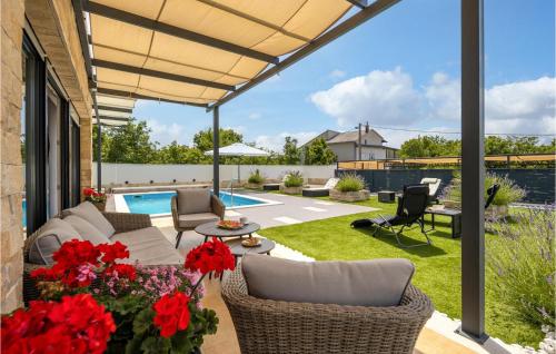 a patio with a couch and chairs and flowers at Villa Manali in Jadranovo