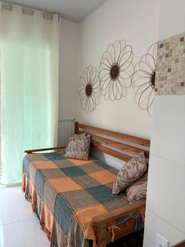 a bedroom with a bed and flowers on the wall at Residencial Morro de São Paulo in Morro de São Paulo