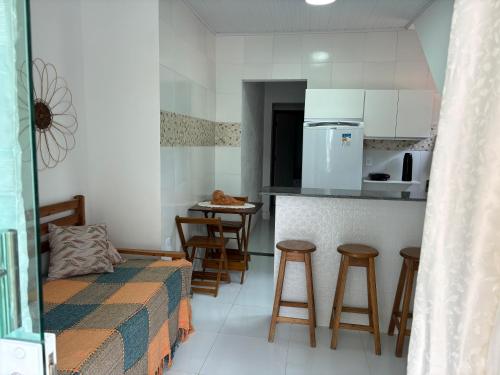 a kitchen with a bed and a counter with stools at Residencial Morro de São Paulo in Morro de São Paulo