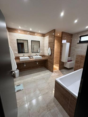 a large bathroom with two sinks and a tub at Villa Kulacs in Veľký Meder