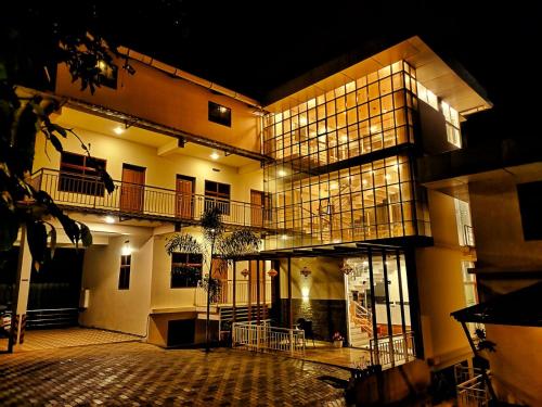 a large building with lights on it at night at Mizzle Resort in Padinjarathara