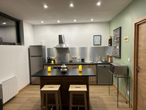 a large kitchen with a counter and stools in it at Gites les Amourettes in Saint-Aubin-sur-Scie